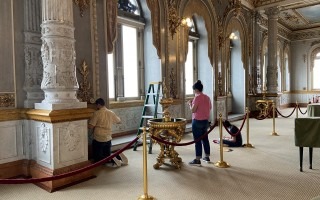 Vista general del foyer del Teatro Nacional donde tres personas toman muestras no invasivas del inmueble.