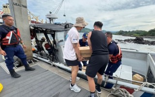Imagen de 5 personas trabajando en Isla Caballo. Están cargando la lancha con donaciones.