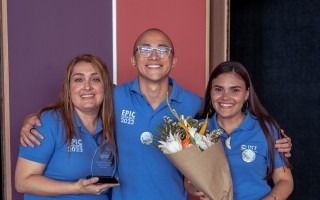 Los tres jóvenes posando con camisas de EPIC y un ramo de flores.