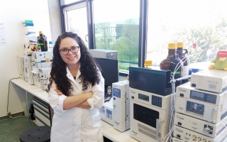 Laura Calvo, de pie, frente a unas máquinas en el laboratorio.