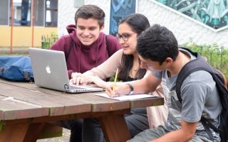 imagen de tres estudiantes  frente a una computadora