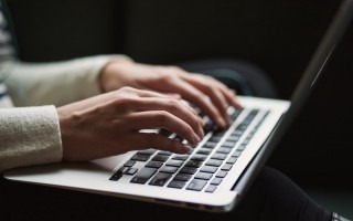 La imagen muestra las manos de una personas tecleando una computadora 