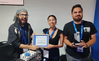 Imagen de tres estudiantes mostrando el premio