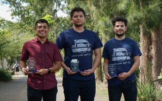 Imagen de tres estudiantes con el premio obtenido en el concurso: Reto Bushido.