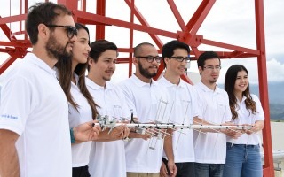 Los estudiantes posan frente a una antena de comunicaciones.