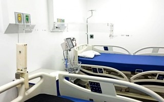 El dispositivo, transparente, sobre una cama de hospital.