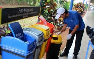 Un hombre saca desechos de un recipiente de reciclaje.