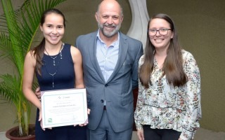 imagen de dos mujeres y un hombre posando para la fotografía con un reconocimiento que ganó el TEC.