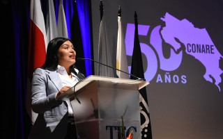 María Estrada con el logo de CONARE atrás.