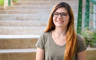 Imagen de una estudiante sentada posando para la fotografía.