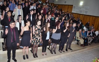 Estudiantes con la mano derecha levantada siendo juramentados. 