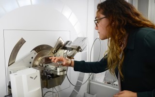 Una joven introduce cristales en el difractómetro de rayos X.