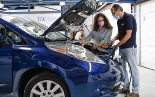 La estudiante y el profesor revisando un vehículo eléctrico.