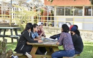 Imagen de varios estudiantes sentados  en una mesita del TEC.