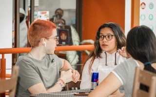 Imagen de tres personas sentadas hablando