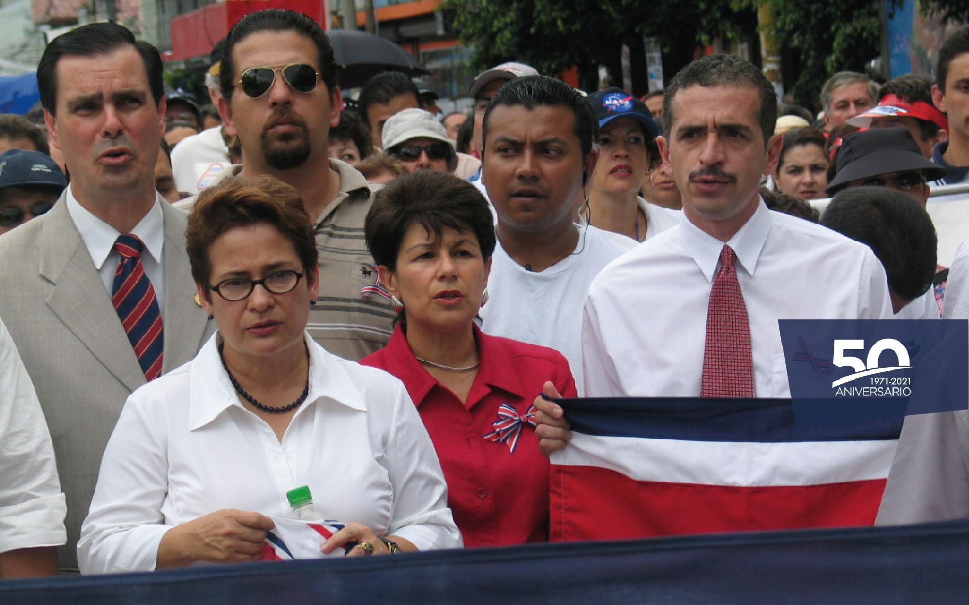Manifestación en vía pública, con banderas de Costa Rica y pancartas.