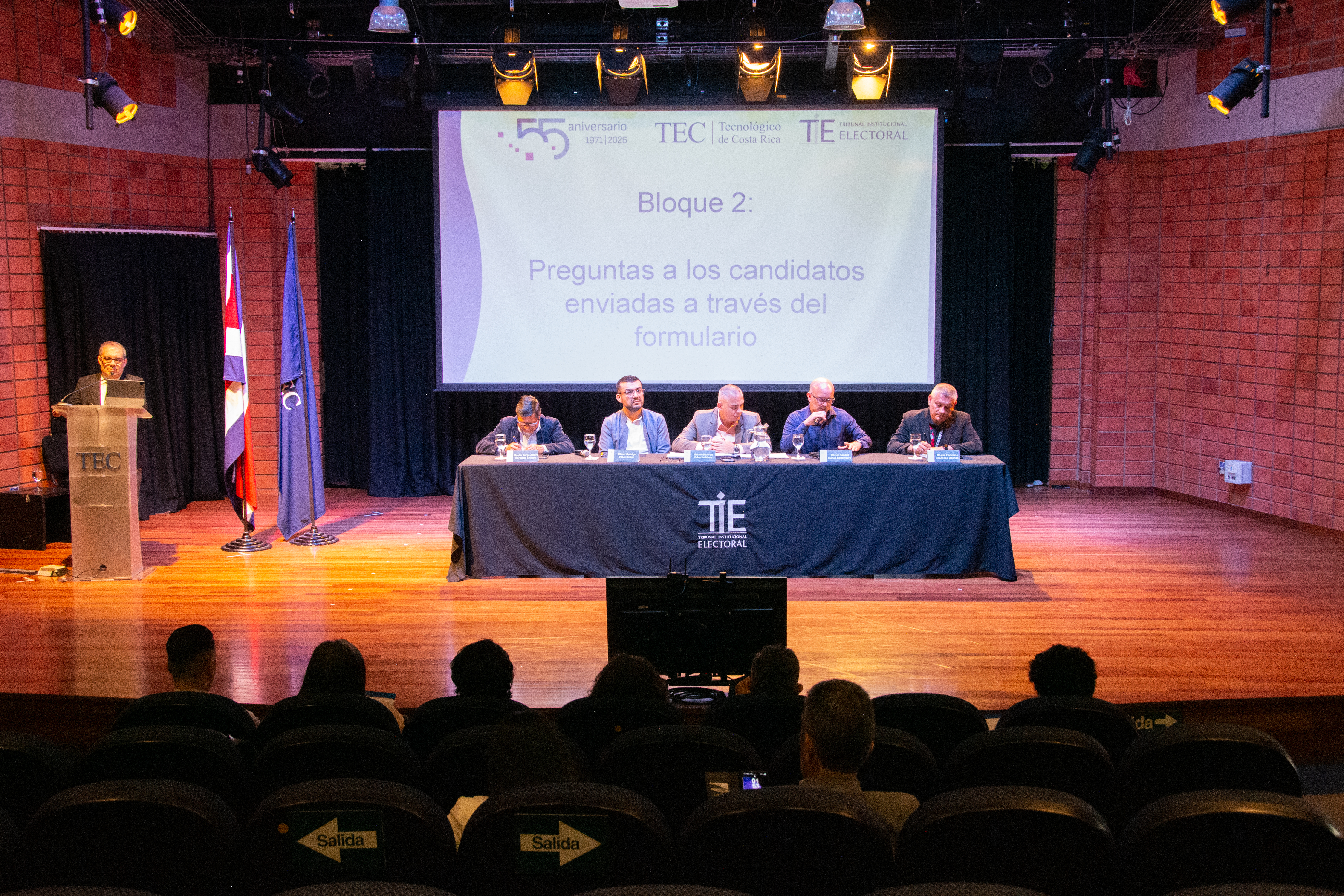 Lo cinco candidatos en la mesa central, ubicada sobre el escenario.