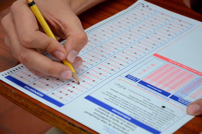 mano de persona con lápiz y examen de admisión