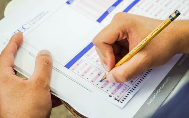 unas manos llenando una hoja de examen