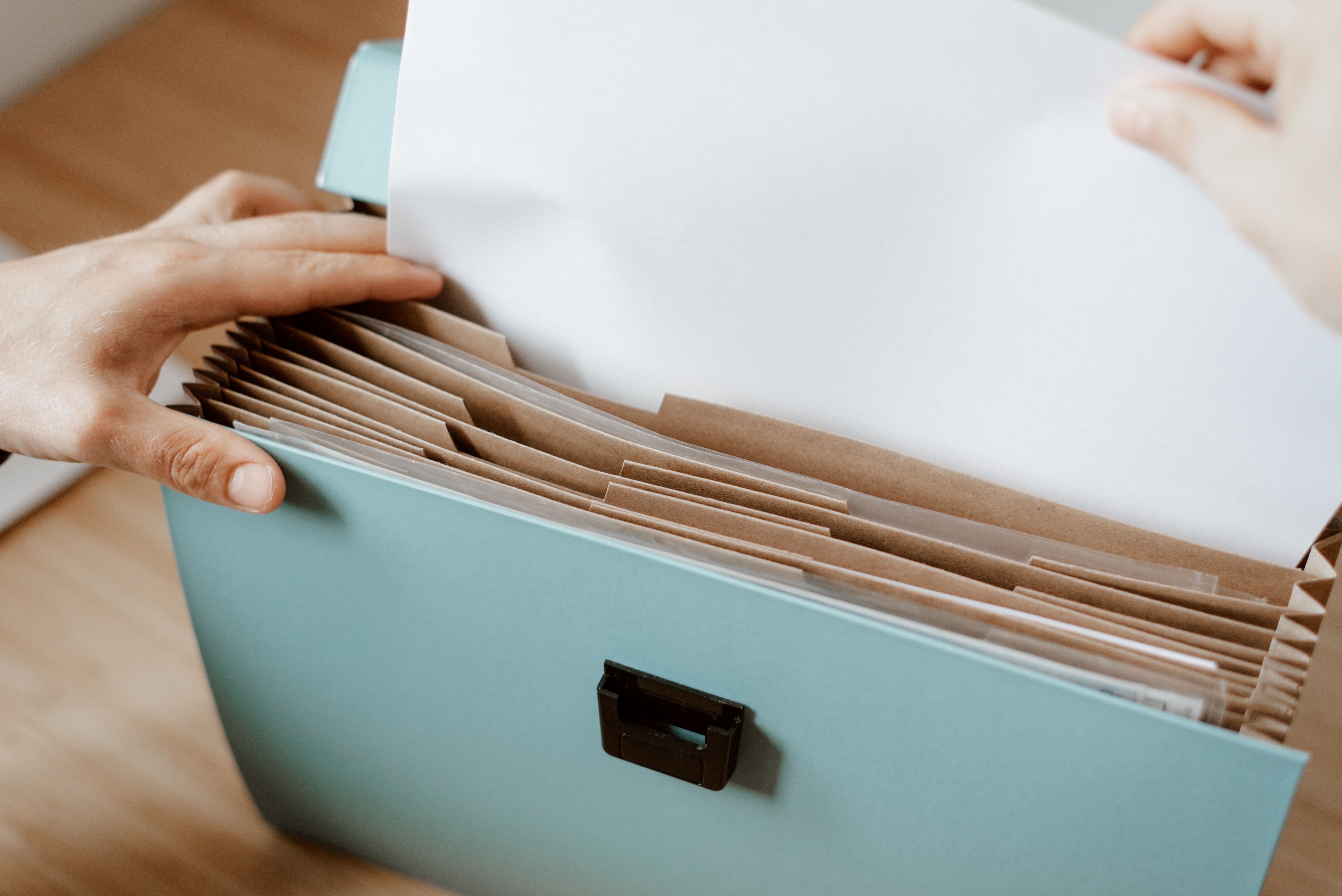 manos de persona buscando en un archivo