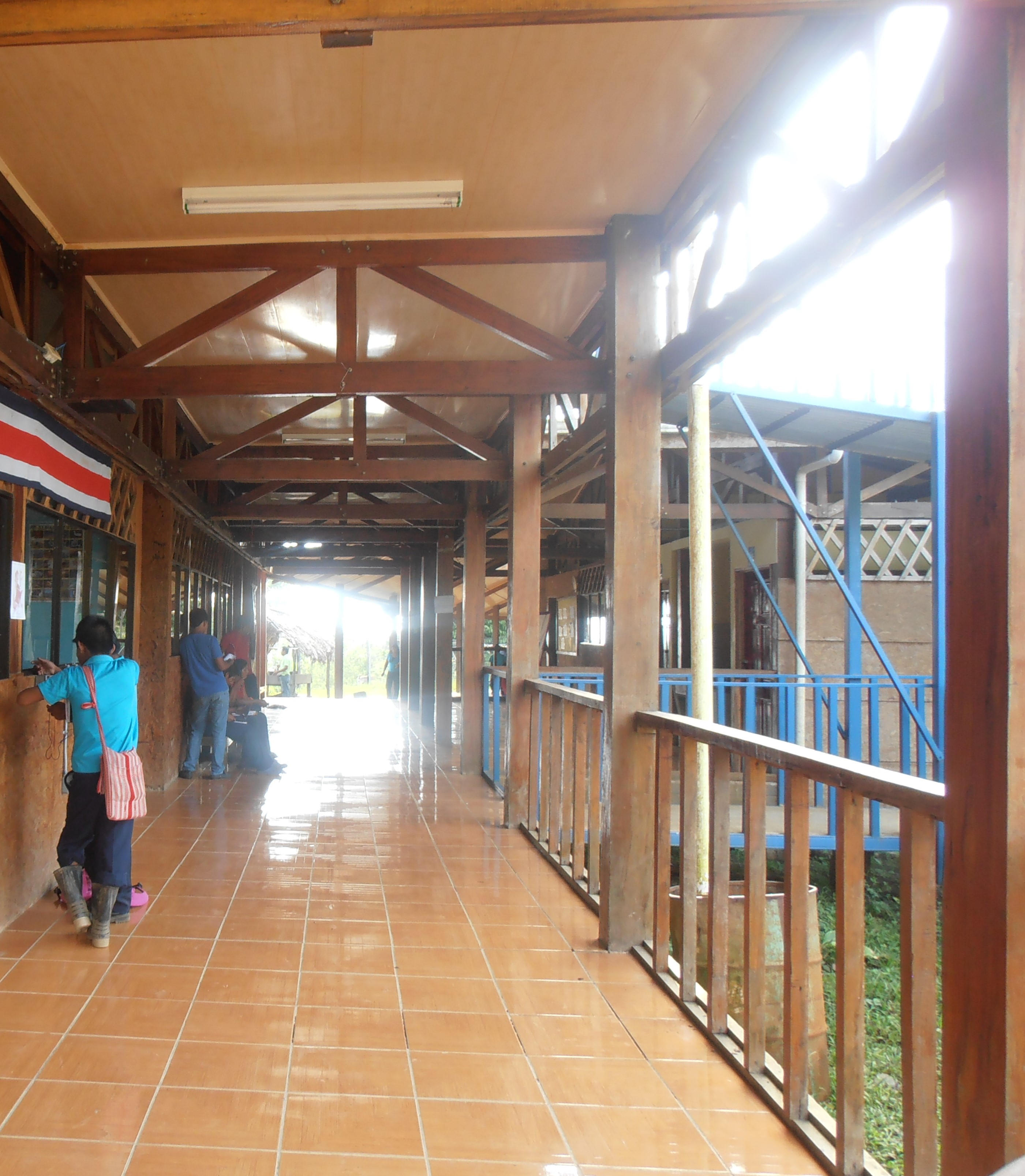 Pasillo de una escuela de las zona sur. Se visualizan dos estudiantes indígenas de espaldas