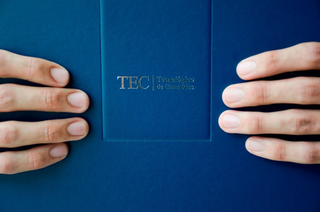 Imagen ilustrativa de un título del TEC. Una persona lo sostiene con sus manos. Únicamente se ven las manos y el título.
