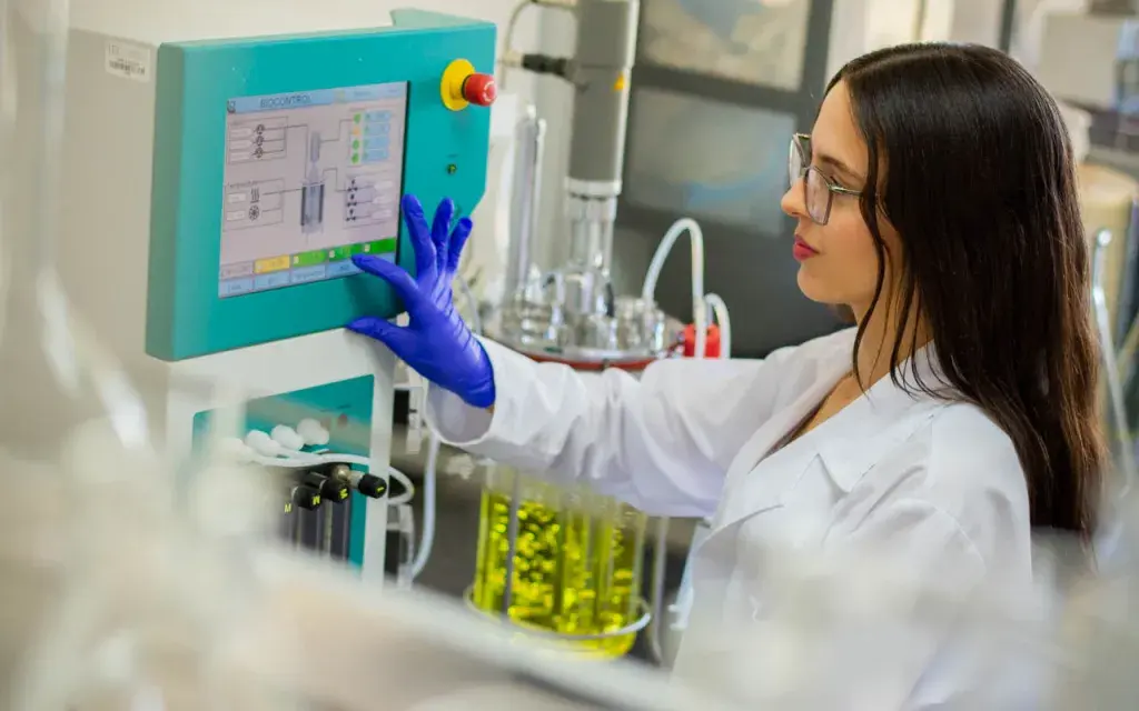 Jovenen con ropa de laboratorio en una pantalla