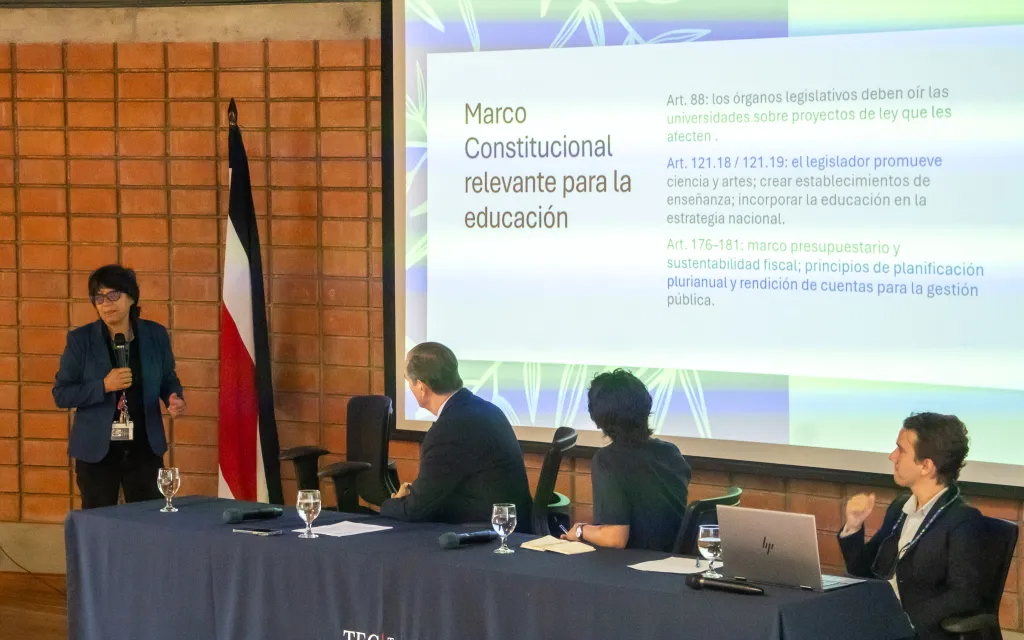 personas realizan ponencia en un auditorio