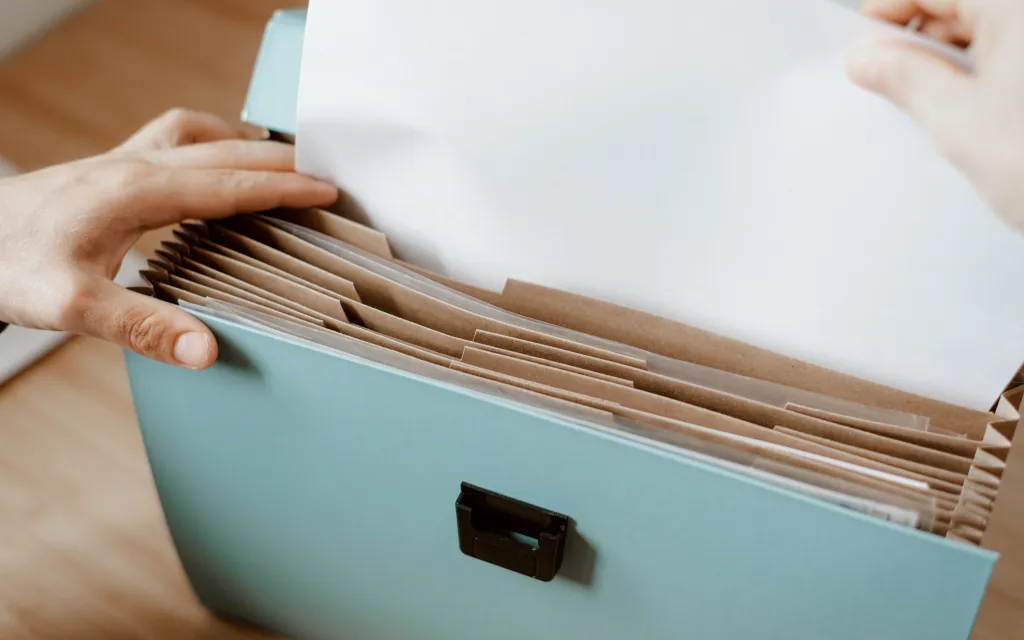 manos de persona buscando en un archivo