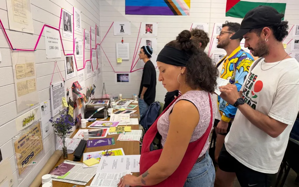 La fotografía muestra personas viendo la exposición