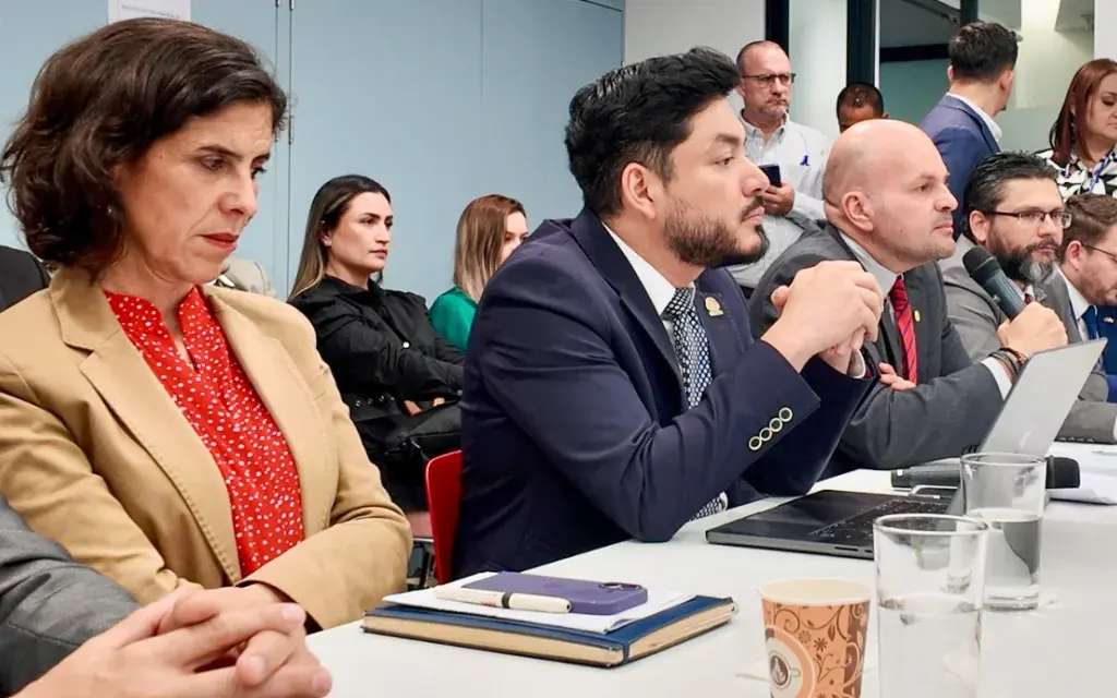 Jerarcas en la mesa con el micrófono.