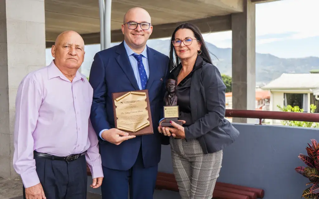 El investigador Valverde, con el premio y junto a sus padres.