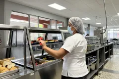 persona sirviendo fruta en la barra de comidas