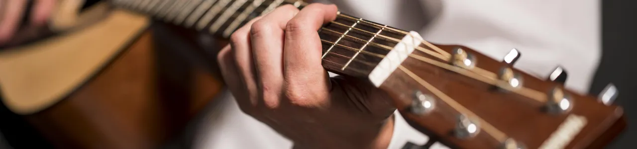 Detalle de una mano haciendo un acorde con una guitarra