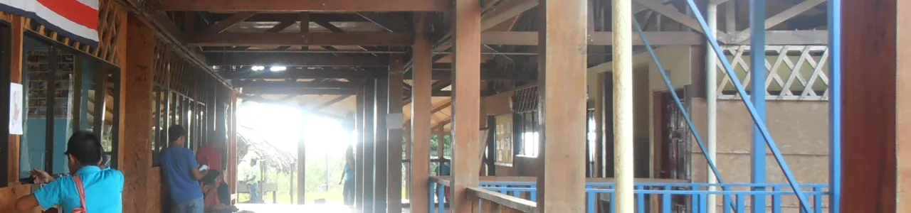 Pasillo de una escuela de las zona sur. Se visualizan dos estudiantes indígenas de espaldas