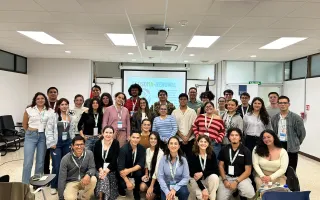 Grupo numeroso de personas de pie y en cuclillas en una sala del TEC, posando frente a una pantalla con el logo de ECOSOMA-RENUWAL.
