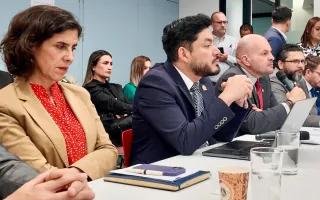 Jerarcas en la mesa con el micrófono.