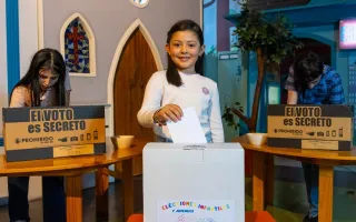 Imagen de una niña emitiendo el voto.