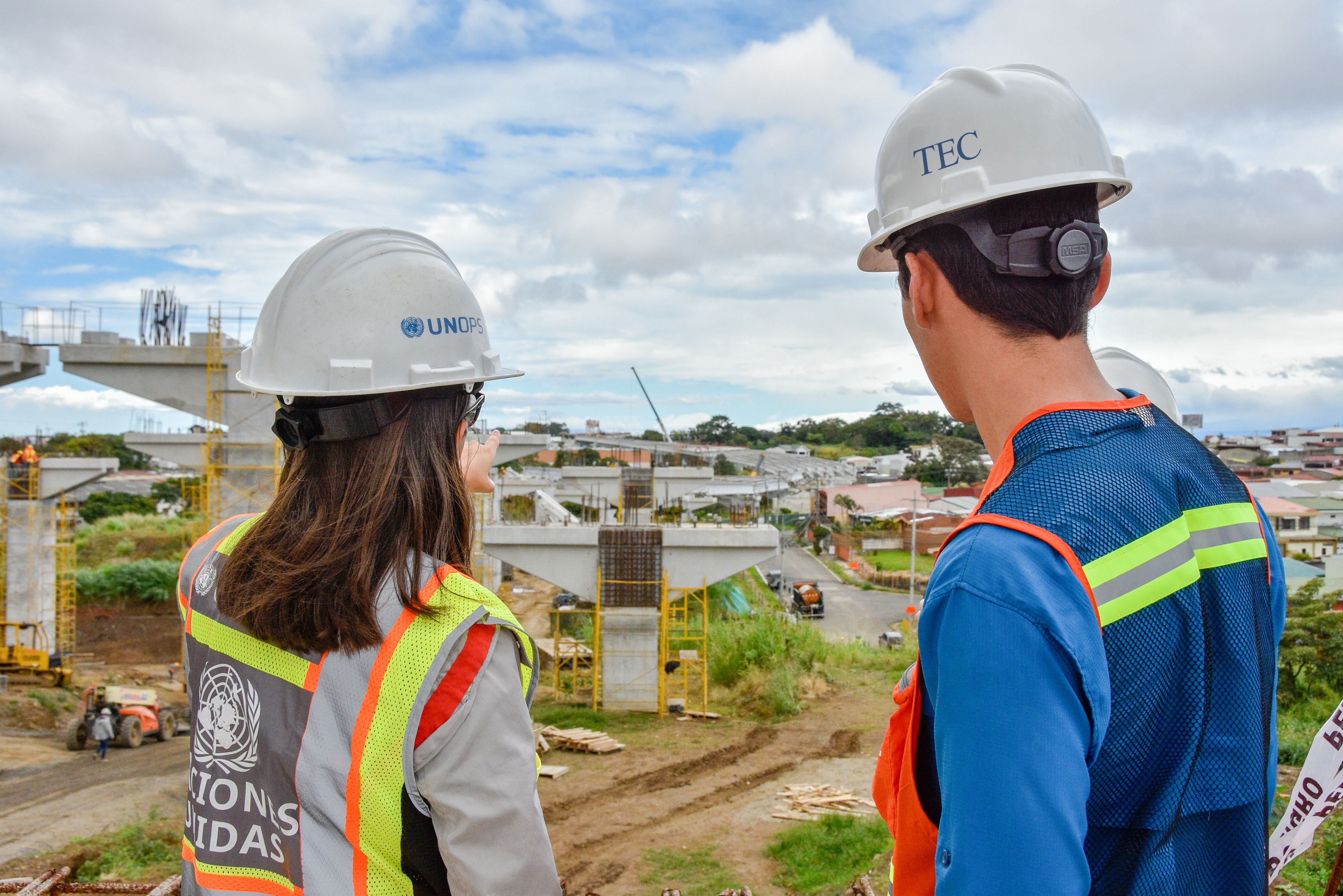 Personas ingenieras viendo un viaducto en construcción 