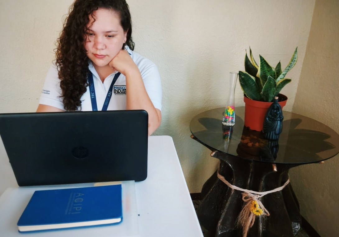 Estudiante sentada frente a una computadora.