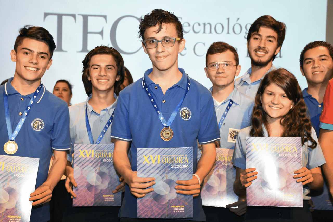 Estudiantes de colegio mostrando un libro. 