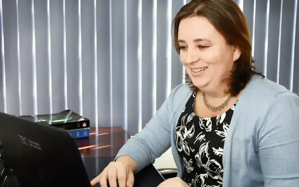 Profesora viendo una computadora.